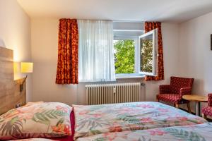 ヘーヘンシュヴァントにあるFerienwohnung Haus Irmaのベッドルーム1室(ベッド1台、窓、椅子付)