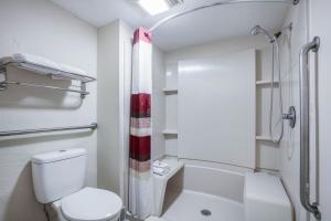 a white bathroom with a toilet and a shower at Red Roof Inn Forrest City in Forrest City