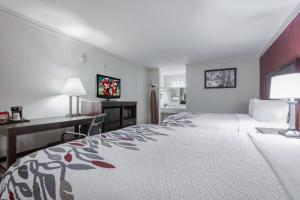 a hotel room with a large bed and a desk at Red Roof Inn Forrest City in Forrest City