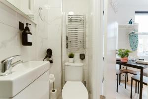 Baño blanco con aseo y lavamanos en The Finsbury Park Star Apartments en Londres