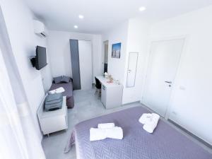 Habitación blanca pequeña con cama y lavamanos en Al Centro Storico, en Caltagirone