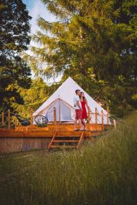 a man and woman standing in front of a tent at Glamping U hranic in Červená Voda