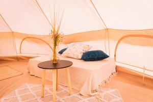 a room with a bed in a tent with a table at Glamping U hranic in Červená Voda