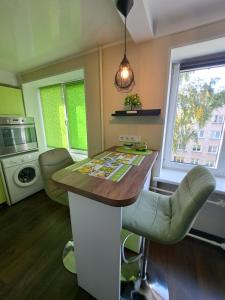 une cuisine avec un comptoir, des chaises et une table dans l'établissement Kosmos, à Daugavpils
