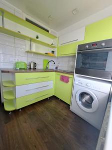 a kitchen with green cabinets and a washing machine at Kosmos in Daugavpils