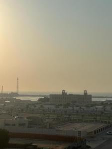 a view of a city with buildings and the ocean at Private Room - Apartment in Al Ḩayrah