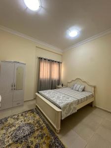 a bedroom with a large bed and a window at Private Room - Apartment in Al Ḩayrah