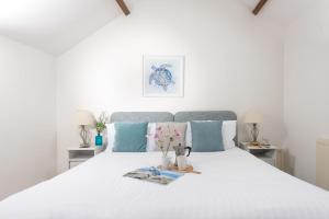 a bedroom with a large white bed with blue pillows at Laity Vean Hideaway in Carbis Bay