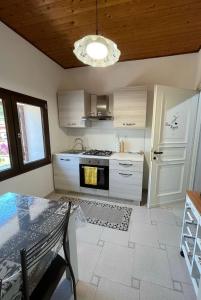 a kitchen with a table and a stove top oven at Le Sorgenti Guest House in Ilbono