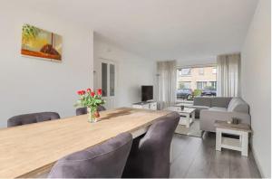 uma sala de jantar com uma mesa de madeira e cadeiras em Apeldoorn- ruime eengezinswoning met 5 slaapkamers em Apeldoorn