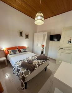 a bedroom with a large bed and a ceiling at Le Sorgenti Guest House in Ilbono