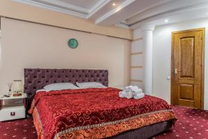 a bedroom with a bed with a red bedspread at Star Rent Hotel in Chişinău