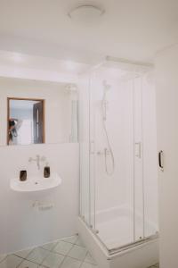 baño blanco con ducha y lavamanos en Apartament Serce Łodzi, en Łódź