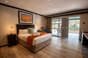 a bedroom with a large bed and a balcony at Arebbusch Travel Lodge in Windhoek