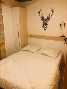a bedroom with a bed with a deer head on the wall at Chalet 77 proche S Besse in Égliseneuve-dʼEntraigues