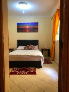 1 dormitorio con 1 cama y una pintura en la pared en Duplex Malika en El Jadida