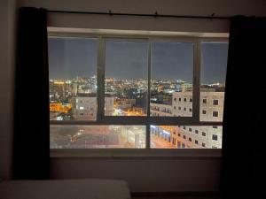 a window with a view of a city at night at Eman Regency Hotel in Ar Ru‘āh