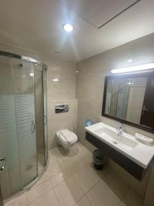a bathroom with a toilet and a sink and a shower at Eman Regency Hotel in Ar Ru‘āh +23 photos