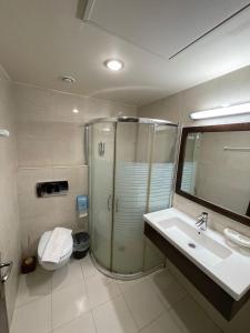 a bathroom with a shower and a sink and a toilet at Eman Regency Hotel in Ar Ru‘āh