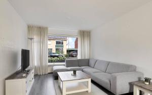 uma sala de estar com um sofá e uma televisão em Apeldoorn- ruime eengezinswoning met 5 slaapkamers em Apeldoorn