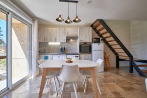 una cocina con mesa y sillas y una escalera en La Mottinière, en Saint-Hilaire-du-Rosier