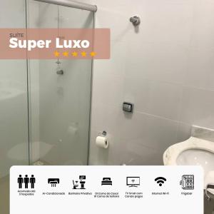 a bathroom with a shower and a sign that reads super luxo at Arcos Palace Hotel in Arcos