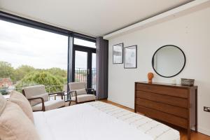 a bedroom with a bed and a mirror at The Shoreditch Escape - Lovely 2BDR Flat with Balcony in London