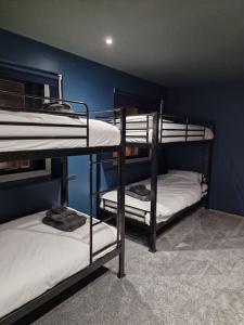 Luxury central Newcastle apartment, sleeps 8 في نيوكاسل أبون تاين: سريرين بطابقين في غرفة ذات جدار أزرق