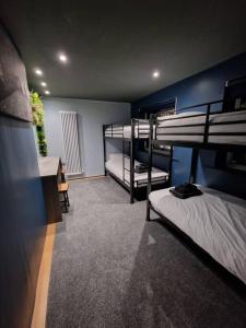 Luxury central Newcastle apartment, sleeps 8 في نيوكاسل أبون تاين: غرفة بسريرين بطابقين ومكتب