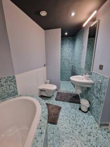 een badkamer met een bad, een toilet en een wastafel bij Luxury central Newcastle apartment, sleeps 8 in Newcastle upon Tyne