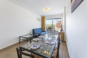 uma sala de jantar com uma mesa e um sofá azul em Esplendor em Casas Devesa