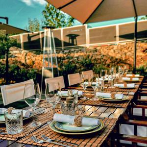 una larga mesa de madera con platos y copas de vino en SISU Guest House, en Esposende