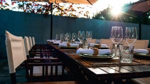 a long wooden table with wine glasses on it at SISU Guest House in Esposende