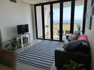 een woonkamer met een bank en uitzicht op de oceaan bij Point Beach #Accommodation - Durban Beach & Waterfront Canals EPIC VIEWS in Durban