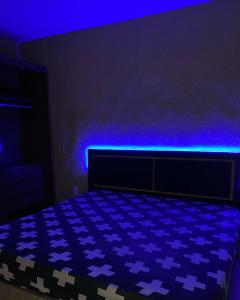 a minecraft bedroom with a bed with blue lighting at Casa com piscina in Armacao dos Buzios