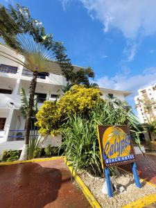 ein Schild vor einem Gebäude mit einer Palme in der Unterkunft Calypso Beach Hotel in Boca Chica