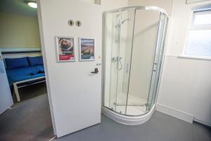 a shower with a glass door in a room at Kirkwall Youth Hostel in Kirkwall