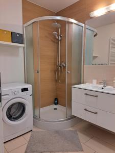 a bathroom with a shower and a washing machine at Adam apartmán in Košice