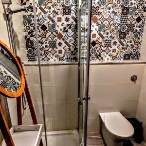 a small bathroom with a shower and a toilet at Townhouse 88 cloudy room in Sliema