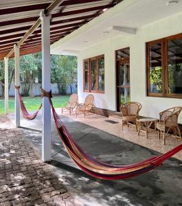 a porch with a hammock outside of a house at The Dom hotel & restaurant in Ahangama