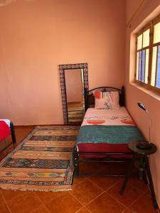 Dormitorio con cama con espejo y alfombra en Maison vallée de l'Ourika en Marrakech