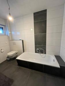 a bathroom with a bath tub and a toilet at Ferienwohnung in Arnoldstein in Arnoldstein