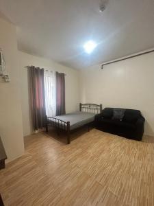 1 dormitorio con 1 cama y 1 sofá en una habitación en BRIA FLATS LAS PINAS en Manila