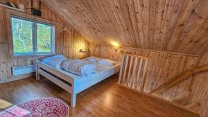 a bedroom with a bed in a wooden room at Fjâllnäs Camping & Lodges in Ã–stra Malmagen
