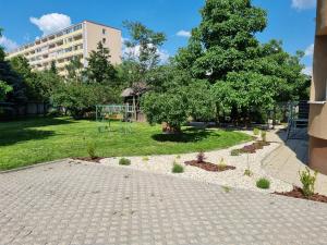a park with a tree and a playground at Apartman Centrum Mudronova in Košice