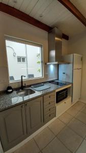 a kitchen with a sink and a refrigerator and a window at HOME UNO ESPERANZA a 2 cuadras de peatonal in Resistencia