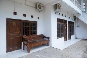 Seturan的住宿－RedDoorz near Plaza Ambarrukmo Yogyakarta，坐在大楼前的木凳