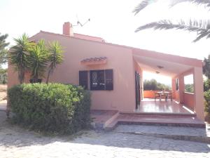 een klein huis met een veranda en een patio bij Calasapone Holiday Home in SantʼAntìoco