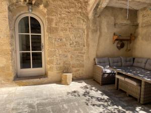 a room with a table and a couch and a window at Le Petit Egregore, patio et climatisation in Lauris