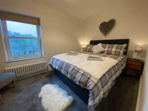 a bedroom with a bed with a heart on the wall at Angel's Cottage in Buxton
